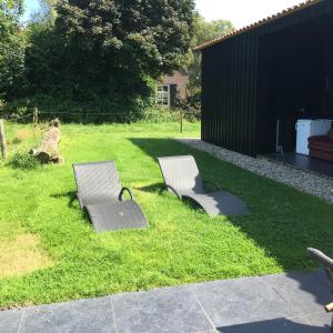 two benches sitting on the grass in a yard at Gastenverblijf Eindhoven in Eindhoven +7 photos