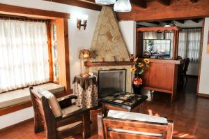 un soggiorno con camino, tavolo e sedie di Apart Cascadas a San Martín de los Andes