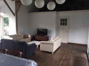 a living room with two couches and a tv at Gastenverblijf Eindhoven, 6 persoons in Eindhoven