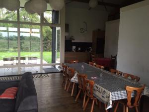 a dining room with a table and chairs and a large window at Gastenverblijf Eindhoven, 6 persoons in Eindhoven