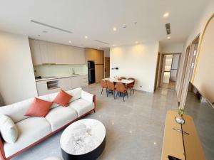 a living room with a white couch and a table at Căn hộ tại các tòa ICON40 - ALACARTE - NEW LIFE TOWER in Ha Long