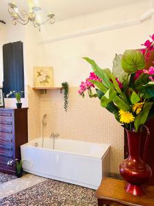 a bathroom with a bath tub with flowers in a vase at Porto Di Colombo - Affittacamere vicino spiaggia e città in Genoa +17 photos