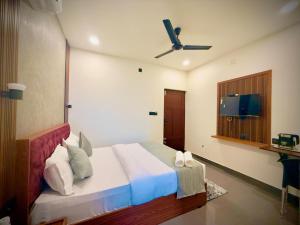a bedroom with a bed with a ceiling fan at Nakshatra in Kovalam