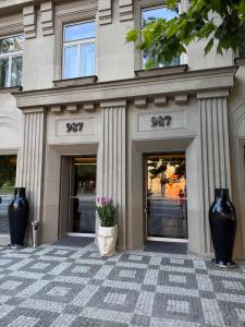 a building with two entrances with vases on the sidewalk at 987 Design Prague Hotel in Prague