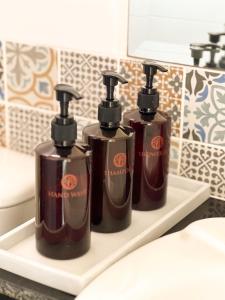 three bottles of soap on a shelf in a bathroom at Pim's Bed and Breakfast @ Phuket in Ban Bang Khu +25 photos