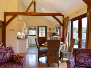 a kitchen and living room with a table and chairs at Lavender Lea in Landford