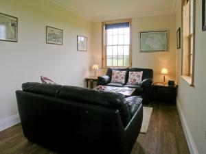 a living room with a black couch and a window at Rascal Wood in Holme upon Spalding Moor