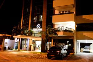カンポ・グランデにあるホテル モハビの夜間の建物前に停車する車