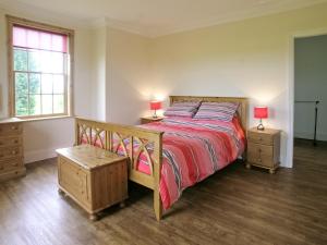 a bedroom with a large bed and two night stands at Rascal Wood in Holme upon Spalding Moor