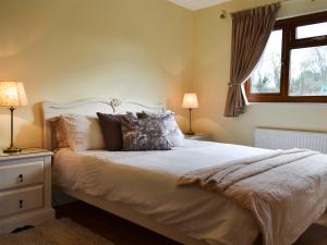 a bedroom with a bed with pillows and a window at Lavender Lea in Landford