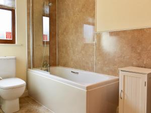 a bathroom with a white tub and a toilet at Lavender Lea in Landford +5 photos