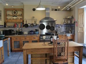 a kitchen with a table and a stove with pots and pans at Holly Lodge in Gilcrux +19 photos