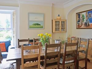 a dining room with a wooden table and chairs at Holly Lodge in Gilcrux