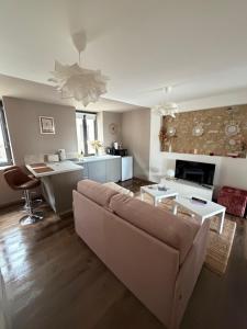 a living room with a couch and a kitchen at L'écrin - Studio Cosy et Lumineux in Andance