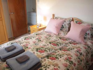 a bed with towels and pillows on top of it at Achnacarry Cottage in Evelix