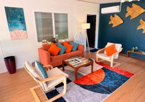 a living room with an orange couch and chairs at Bamboo Beach House @ Phang Nga in Thai Muang