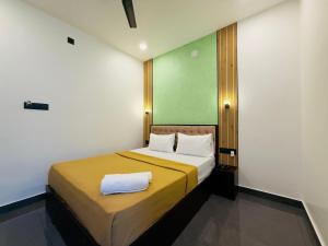 a bedroom with a bed with a towel on it at Nakshatra in Kovalam