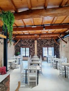 a dining room with white tables and white chairs at Hostal Restaurante LA SENDA in Camponaraya