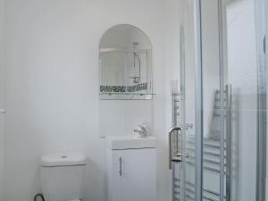 a bathroom with a toilet and a sink and a mirror at La Falda in Sutton on Sea