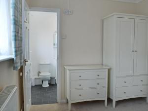 a bathroom with a white cabinet and a toilet at La Falda in Sutton on Sea