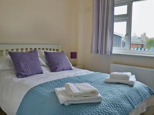 a bed with towels on it with a window at La Falda in Sutton on Sea +3 photos