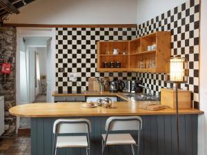 a kitchen with a counter with stools in it at Bakery - Ukc4675 in Clynnog-fawr