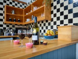 a bottle of wine and two wine glasses on a counter at Bakery - Ukc4675 in Clynnog-fawr