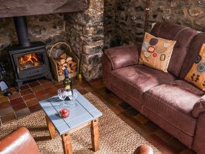 a living room with a couch and a fireplace at Bakery - Ukc4675 in Clynnog-fawr
