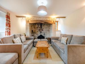 a living room with couches and a fireplace at New Inn Farmhouse in Marnhull