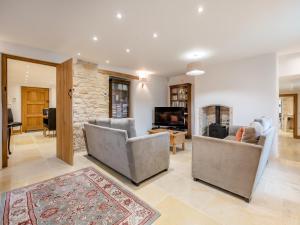 a living room with two chairs and a television at New Inn Farmhouse in Marnhull
