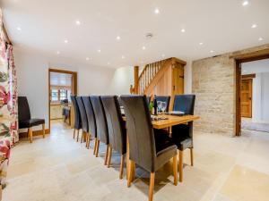 a dining room with a wooden table and chairs at New Inn Farmhouse in Marnhull