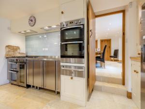 a kitchen with stainless steel appliances and a dining room at New Inn Farmhouse in Marnhull +27 photos