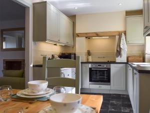a kitchen with a wooden table with bowls on it at Wells Cottage in Hook Norton