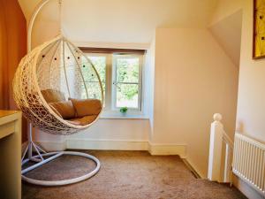 a hanging chair in a room with a window at Wells Cottage in Hook Norton +9 photos