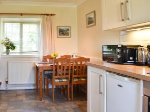 a kitchen with a wooden table with a microwave at Hayloft - Ukc4241 in Lanreath