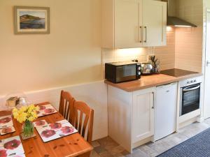 a small kitchen with a table and a microwave at Hayloft - Ukc4241 in Lanreath