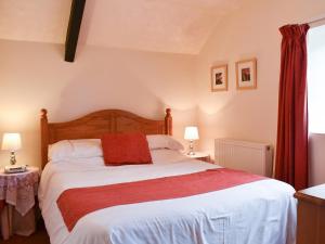 a bedroom with a large bed with a red blanket at Hayloft - Ukc4241 in Lanreath +14 photos