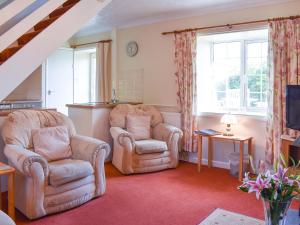 two chairs and a television in a living room at Hayloft - Ukc4241 in Lanreath