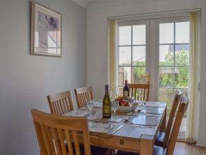 a dining room table with wine bottles and a bowl of fruit at The Marches in Anstruther