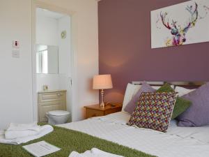 a bedroom with a bed and a toilet and a lamp at The Marches in Anstruther