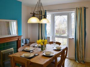 a dining room with a wooden table with yellow flowers at Willow Cottage in Warkworth