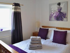 a bedroom with a bed with towels on it at Willow Cottage in Warkworth