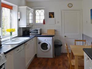 a kitchen with a washing machine and a sink at Willow Cottage in Warkworth
