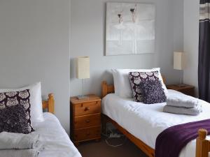 a bedroom with two beds and a dresser with two lamps at Willow Cottage in Warkworth