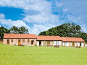 a house with a grassy field in front of it at Hirst House - W41947 in Filey +6 photos