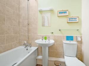 a bathroom with a sink and a toilet and a bath tub at Hirst House - W41947 in Filey