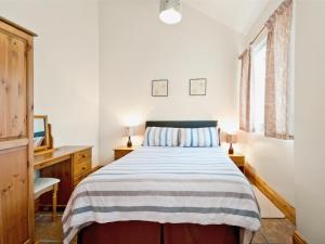a bedroom with a bed and a desk and a window at Hirst House - W41947 in Filey