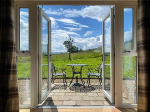 an open door to a patio with a table and chairs at Mark Close Milking Parlour in Alston