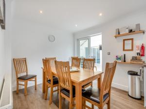 a dining room with a wooden table and chairs at The Willows in Sea Palling