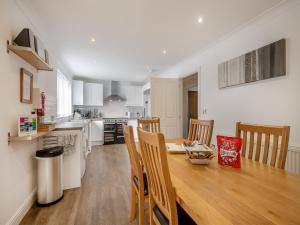 a kitchen and dining room with a wooden table and chairs at The Willows in Sea Palling